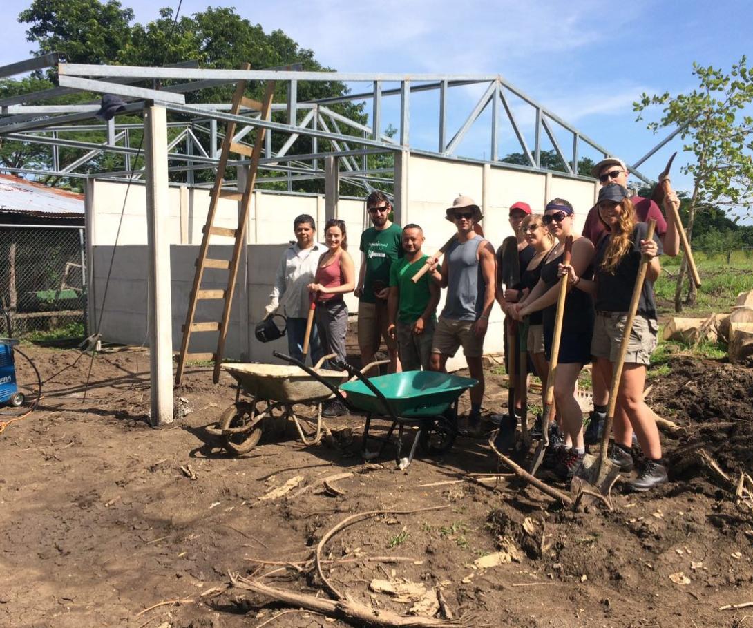 A group of corporate volunteers on a tailor-made trip take a break during building activities in Costa Rica. A corporate group on a bespoke volunteer trip at their building site in Costa Rica.